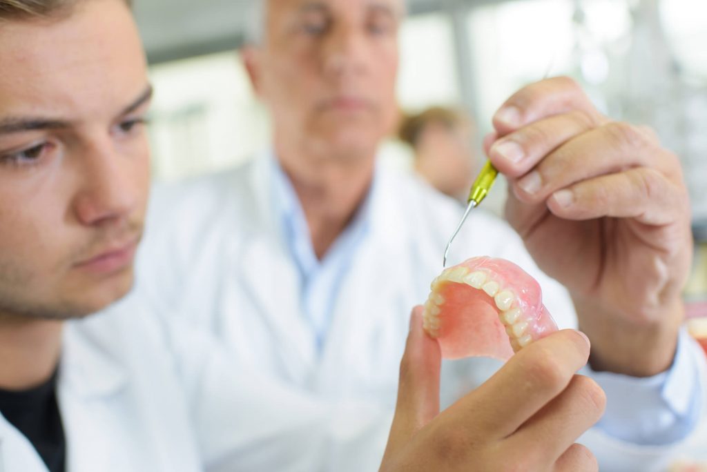 dentist working on a model of dentures in Simpsonville, SC