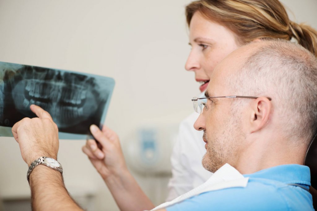 dentist and patient checking X-ray result before an oral surgery in Greenville, SC