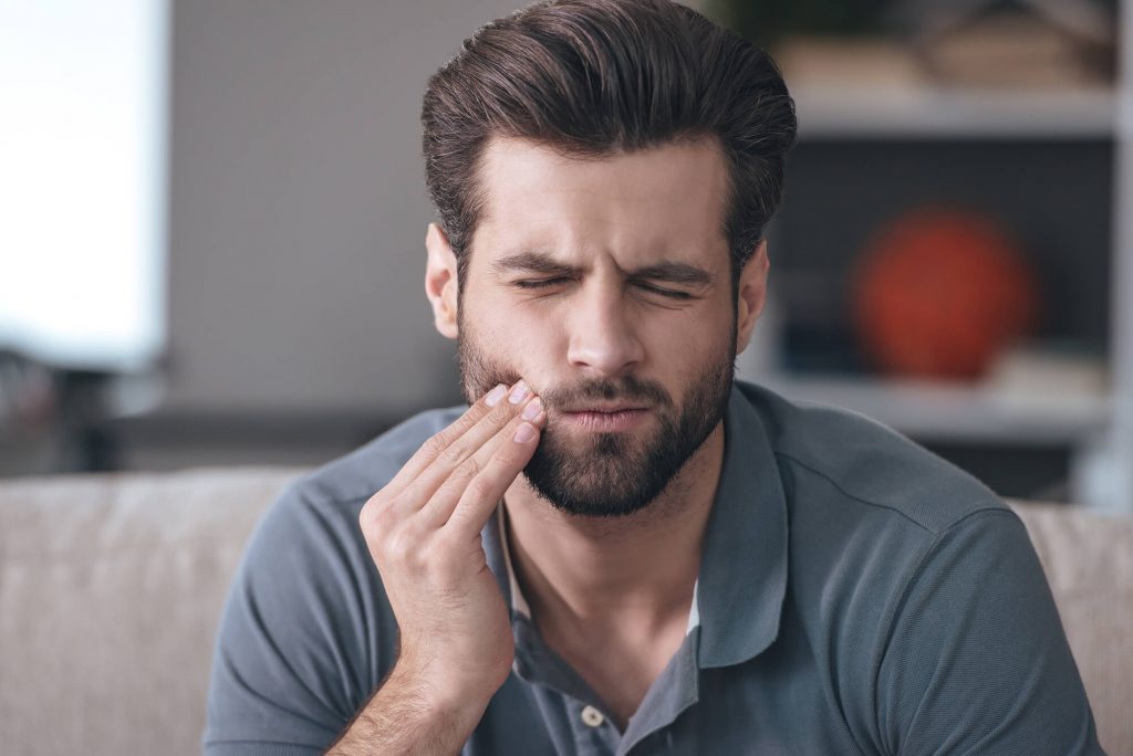 man suffering from toothache and needs an emergency dentist in Simpsonville, SC