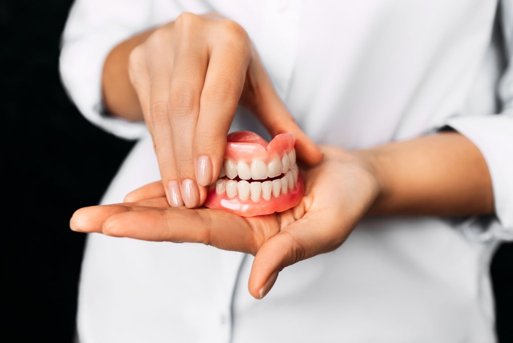 dentist holding dentures in Greenville SC 
